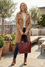 Woman outdoors with a maroon tote bag, beige coat, and boots, Bagvalleypk premium handbags