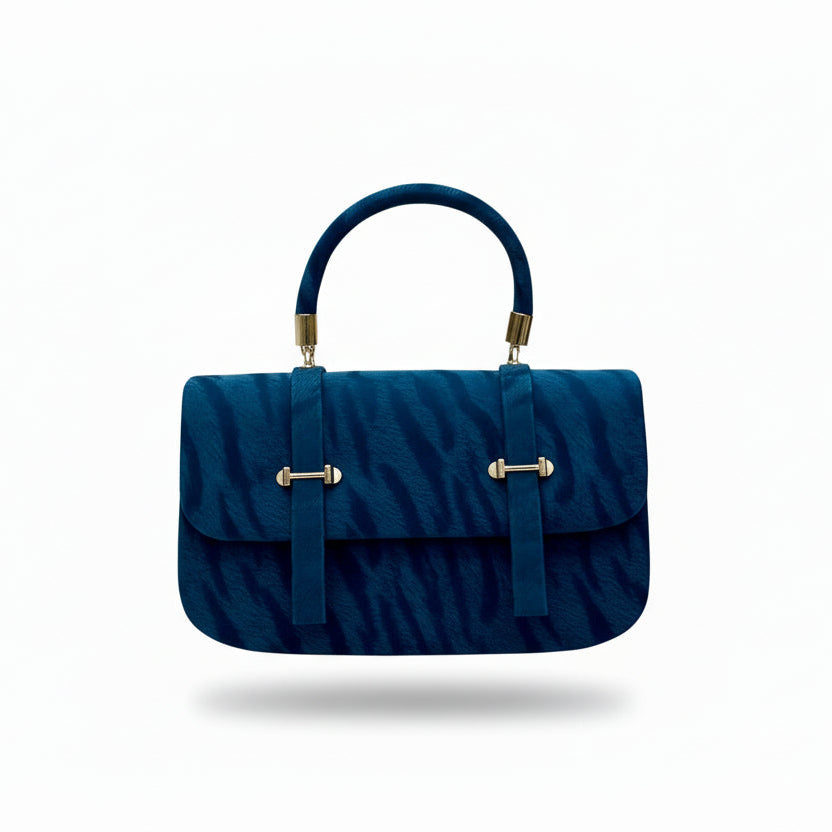 Blue handbag with gold accents on a brown box against a light green background with text.