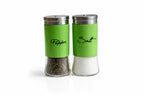 Green salt and pepper shakers with metal lids on white background